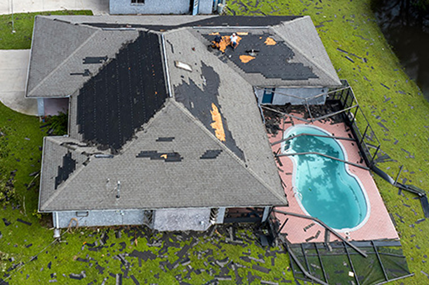 Destroyed house roof by hurricane Ian strong winds in Florida residential area