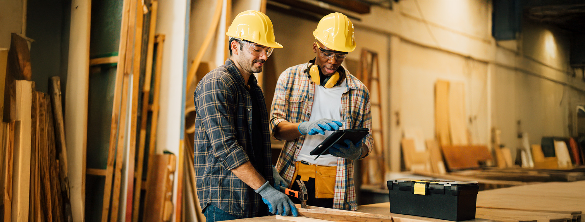 Two Carpenter working on wood craft at workshop to produce construction material or wooden furniture. The young carpenter use professional tools for crafting