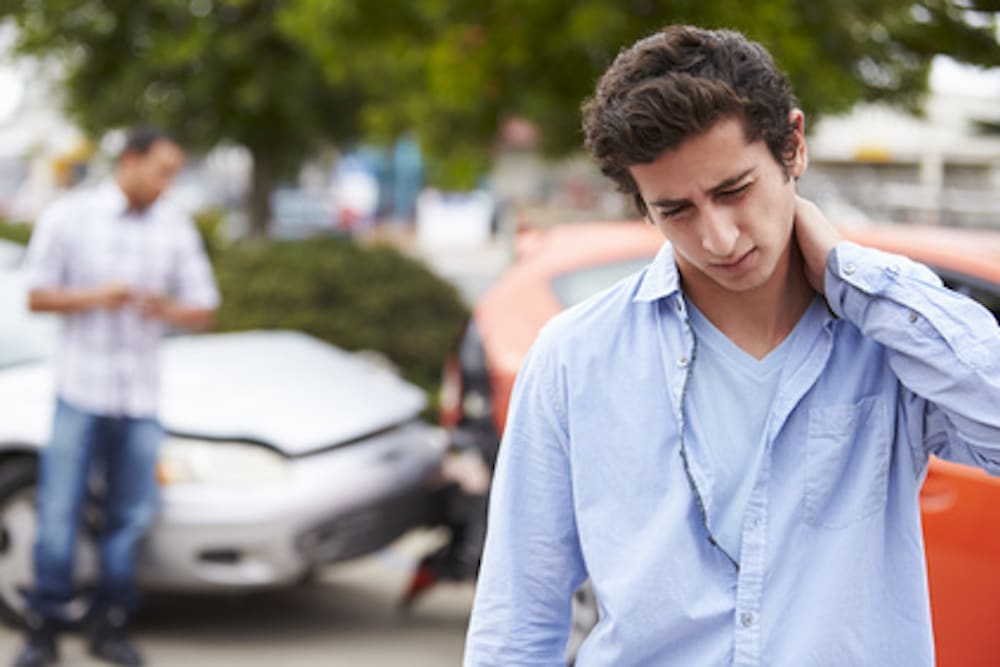 person holding their neck after a car accident