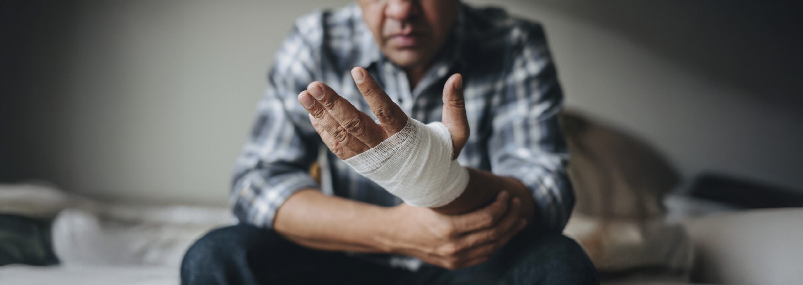 man with a gauze bandage wrapped around his hand scaled