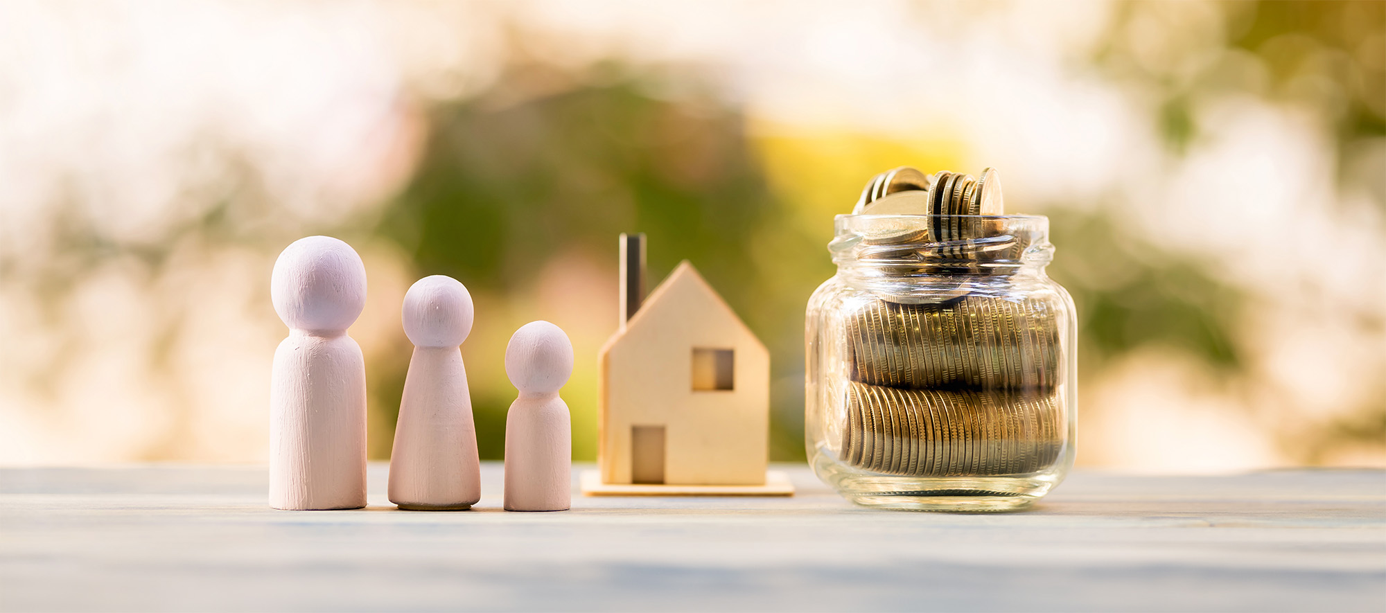 House model and family wood and bottle with gold coin inside of sunlight in the public park